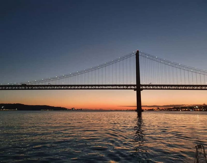 Lisbon: Sunset Sailing Boat Tour with Drinks - Cristo Rei beneath the evening sky