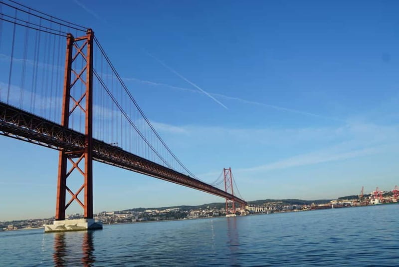 Lisbon: Sunset Sailing Boat Tour with Drinks - The 25th of April Bridge from below