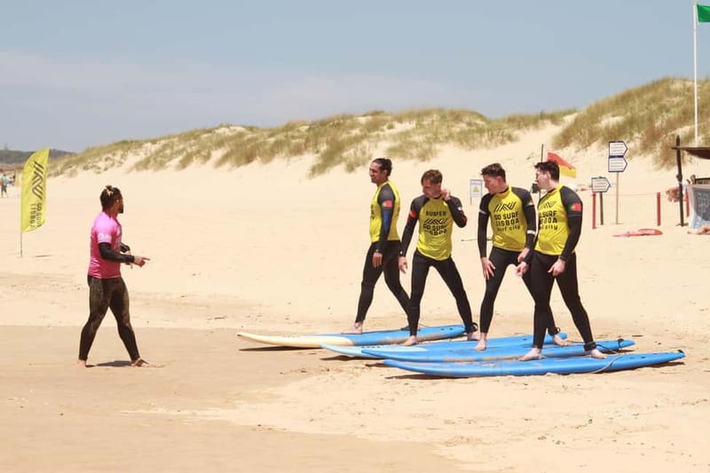 Lisbon: The Surf Instructor - surf lessons with transfer - Getting suited up beside a long sandy beach